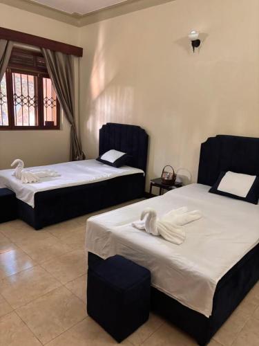 two beds sitting in a room with at Happy Fish Villa in Entebbe