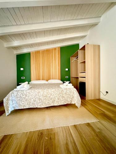 a bedroom with a large bed and green walls at affittacamere Villa Masá in Zingarello