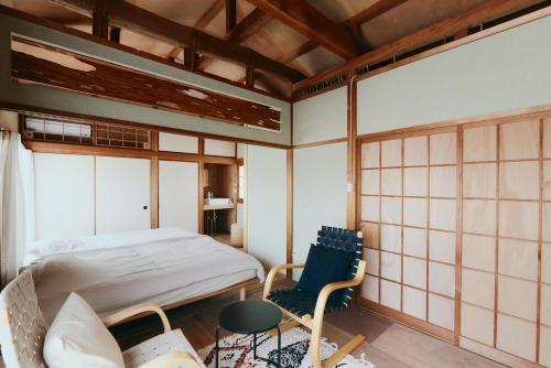 a room with a bed and a chair in it at kawasakike in Takamatsu