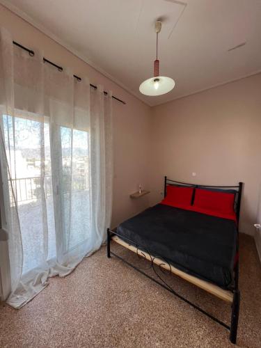 ein Schlafzimmer mit einem Bett und einem großen Fenster in der Unterkunft Light Apartment in Ierápetra