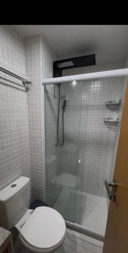 a bathroom with a toilet and a shower with a glass door at Smart Pituba Studio Premium in Salvador