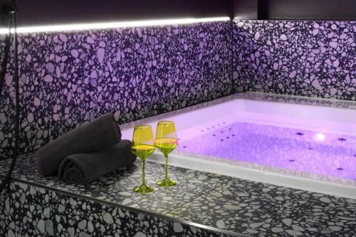 two wine glasses on a table next to a tub at Your very unique private spa in Berlin Kreuzberg in Berlin