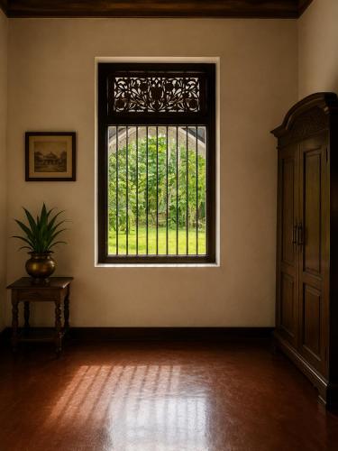 an empty room with a large window in a building at Basnagoda Walawwa in Ruwanwella