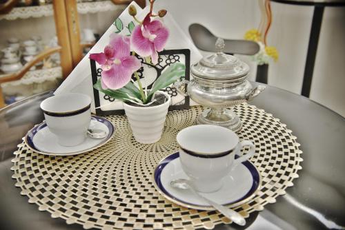 two cups and saucers on a glass table with flowers at Menhir in Olmedo