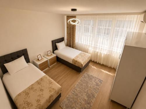 a small bedroom with two beds and a window at Airport Suite Trabzon in Trabzon