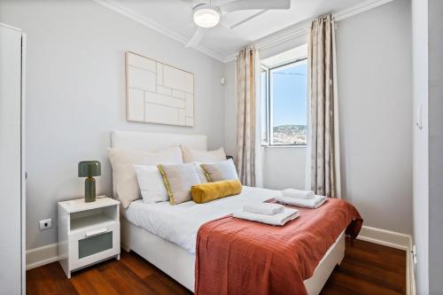 a white bedroom with a bed and a window at Hillside - By WeHost in Funchal