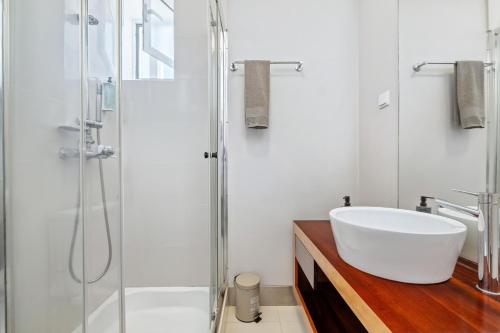 a bathroom with a white sink and a shower at Hillside - By WeHost in Funchal