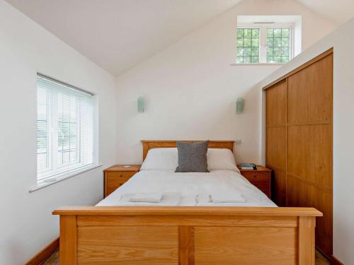 a bedroom with a bed with a wooden headboard at 1 Bed in Lymington oc-83370 in Sway