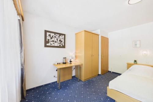 a hotel room with a bed and a desk at Cozy single suite with mountain view in Saas-Almagell