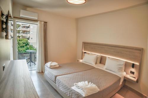 a bedroom with a large bed and a large window at Falassarna Hotel in Chania