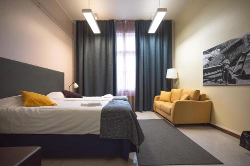 a bedroom with a bed and a chair and a window at LentoHotelli in Kauhava
