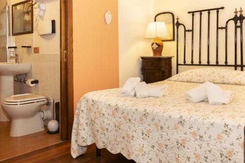 a bedroom with a bed and a toilet and a sink at Il Castello di San Sergio in Centola