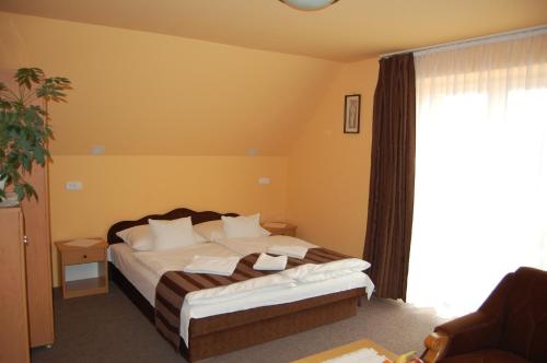 a bedroom with a bed and a large window at Judit Panzio in Gyulakeszi