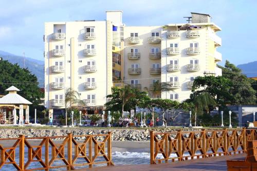 duży biały budynek przed plażą w obiekcie Hotel Art Deco Beach w mieście La Ceiba