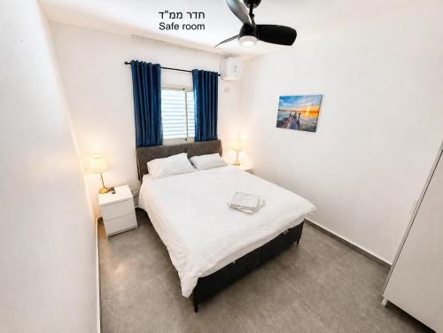 a bedroom with a large bed with blue curtains at בית נופש - הדקל והים אילת in Eilat