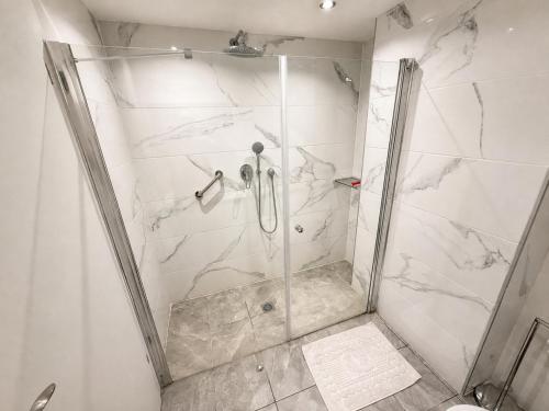 a shower stall with a glass door in a bathroom at בית נופש - הדקל והים אילת in Eilat