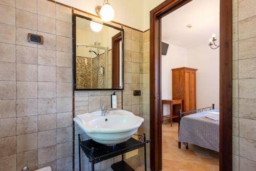 ein Badezimmer mit Waschbecken, Spiegel und Bett in der Unterkunft Hotel Dei Templi in Paestum
