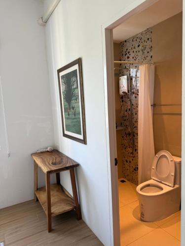 a bathroom with a toilet and a wooden table at Stayokay Sattahip ที่พักสัตหีบ in Sattahip