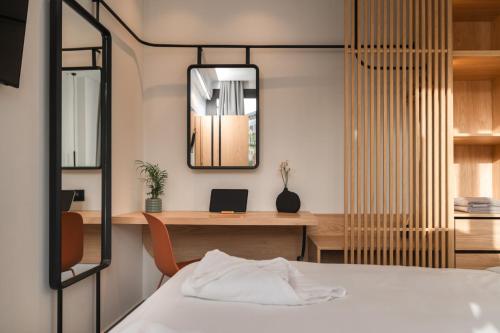 a bedroom with a bed and a desk with a mirror at NAEMA Seafront Living 2BR Suite in Anissaras