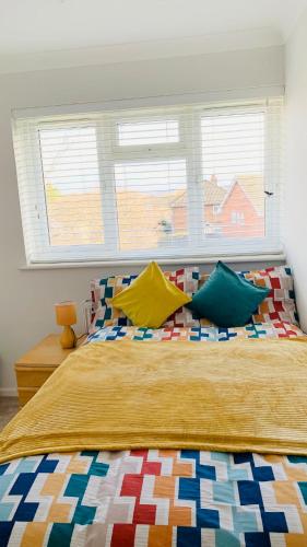 a bedroom with a large bed with colorful pillows at A cosy & peaceful homestay in Sutton