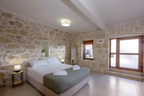 ein Schlafzimmer mit einem Bett und einer Steinwand in der Unterkunft Bastakis Studio Silver in Skalánion
