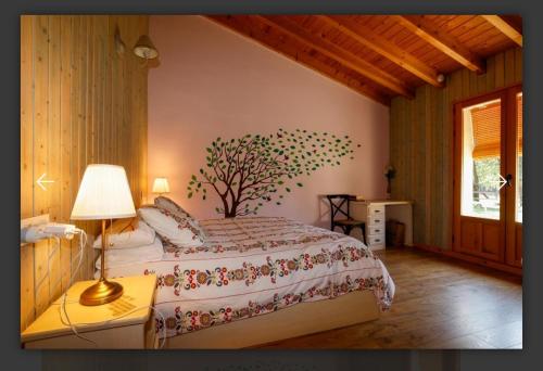 a bedroom with a bed with a tree on the wall at Eco Urbion in Duruelo de la Sierra