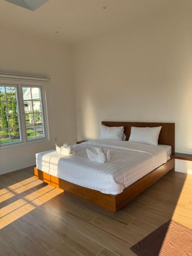 a bedroom with a large bed with two cats on it at Stayokay Sattahip ที่พักสัตหีบ in Sattahip