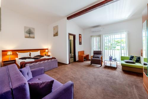 a hotel room with a bed and a couch at Hotel Regal in Costinesti