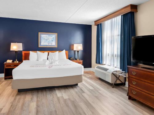 a bedroom with a large bed and a flat screen tv at Best Western Potomac Mills in Woodbridge