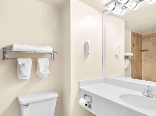 a bathroom with a sink and a toilet and a mirror at Best Western Potomac Mills in Woodbridge