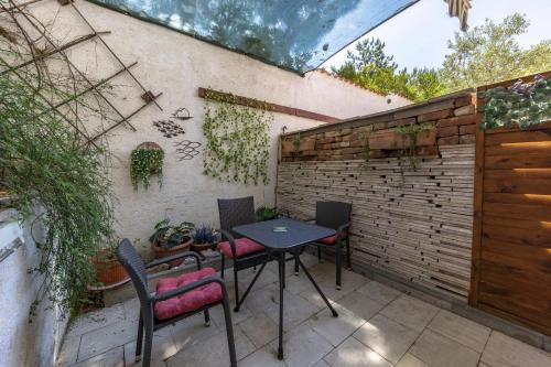 a patio with a table and chairs next to a brick wall at Punta Debij Select Apartments in Punat