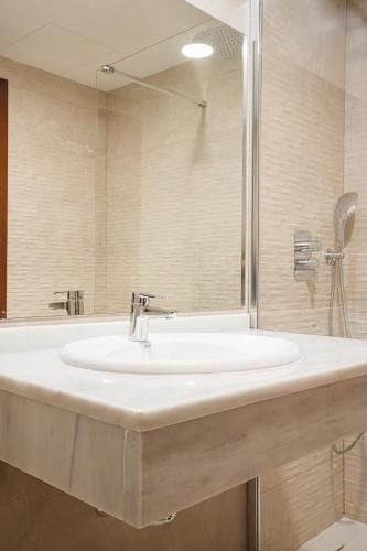 a bathroom with a white sink and a shower at Hotel El Nogal in Peligros
