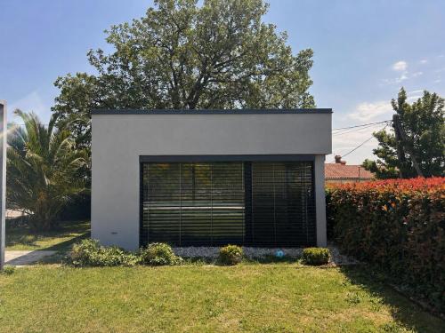 a white building with a large garage door at Počitniška hiška SEA HIDEAWAY in Ankaran