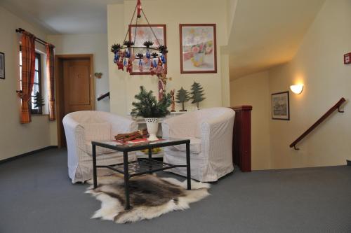 a living room with two chairs and a table at Hotel Landhaus Marienstein in Bergen