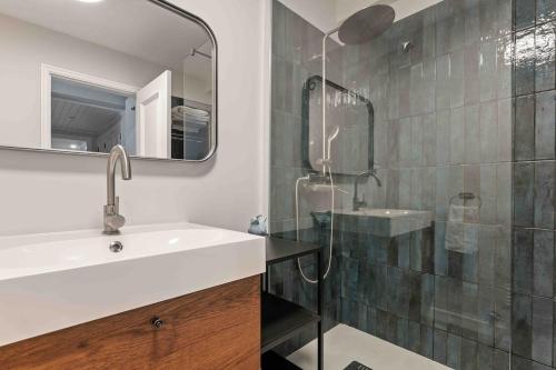 a bathroom with a sink and a shower with a mirror at Estoril Riviera Residences in Estoril