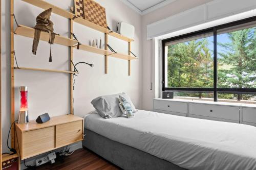 a bedroom with a bed and shelves and a window at Estoril Riviera Residences in Estoril
