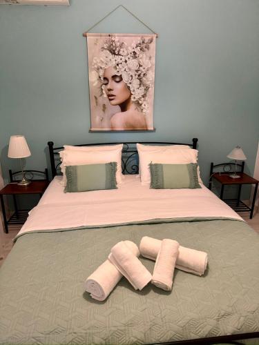 a bed with two slippers on the bed with a picture at AnnaPolys House in Kavála