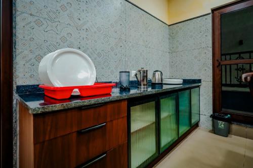 a kitchen with a counter with a plate on it at Akruthi Palm Pavilion Resort in Aldūr