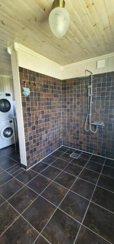 a bathroom with a shower and a tile floor at Michel-Inn-Your Scandinavian Escape! in Faggemåla
