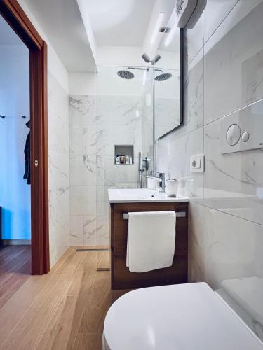 a white bathroom with a sink and a tub at Casa Araiani in Ariano Irpino