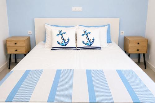 a blue and white bed with two night stands at La Maya in Caleta De Fuste