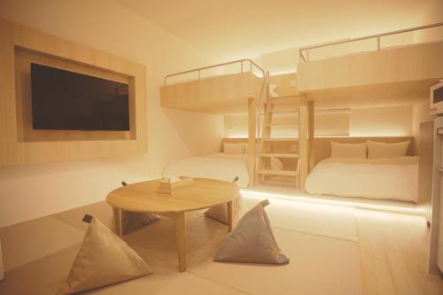 a room with two bunk beds and a table at Amu in Beppu
