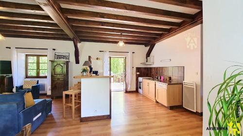 a kitchen and living room with a blue couch at Gîte Scopa in Murol