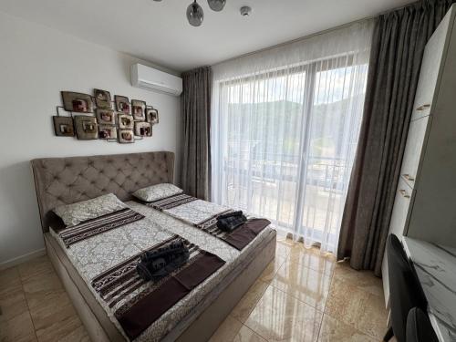 a bedroom with a bed and a large window at VP Onyx Apartment in Elenite