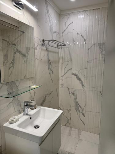 a white bathroom with a sink and a shower at VP Onyx Apartment in Elenite