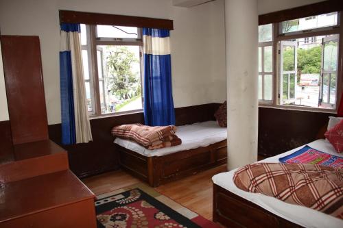 a room with two beds and two windows at Hotel reegyal in Ravangla