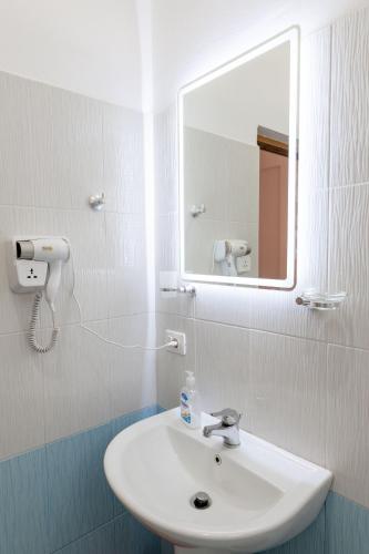 a bathroom with a white sink and a mirror at Center Apartments in Ksamil