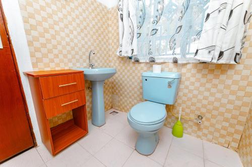a bathroom with a blue toilet and a sink at Chakruok Gardens, Hawi in Bondo