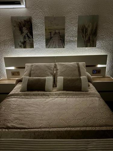 a bed in a bedroom with pictures on the wall at SOLyMAR in Garrucha