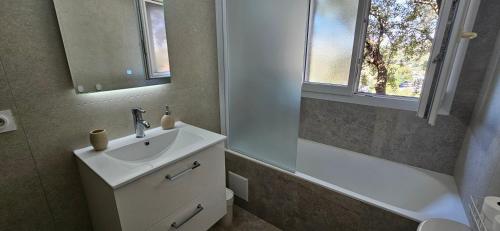 a bathroom with a sink and a mirror and a tub at chez Henri-Ange in Saint-Raphaël